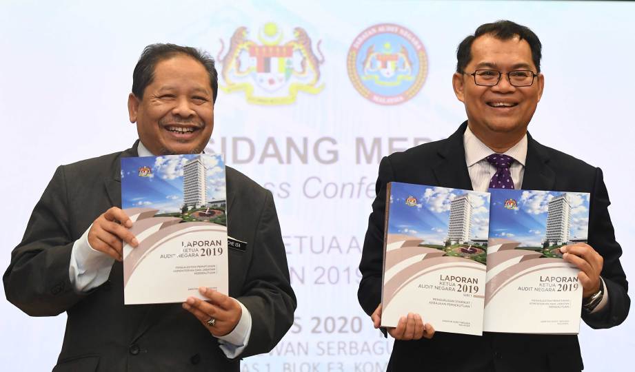 NIK Azman (kanan) menunjukkan buku Laporan Ketua Audit Negara Tahun 2019 Siri Satu di Jabatan Audit Negara, Putrajaya. FOTO BERNAMA