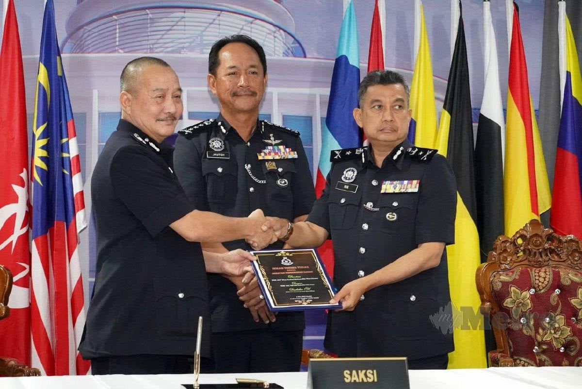 Nik Md Zain (kanan) menerima dokumen sebagai Ketua Jabatan Pengurusan Kontinjen Sabah yang baharu dengan disaksikan Jauteh pada majlis berkenaan. Foto Juwan Riduan