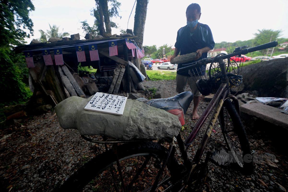 Kuah Leong Chuan, 65, membawa batu nisan yang telah siap dengan tulisan Jawi untuk disimpan sebelum diserahkan kepada pelanggannya. FOTO BERNAMA