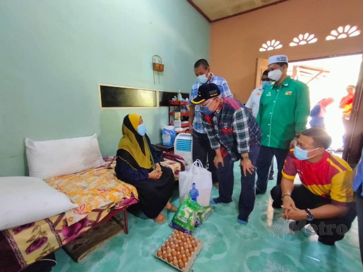Noh Omar (tengah) menziarahi wanita warga emas, Siti Aisah sambil menyerahkan sumbangan bakul makanan di rumahnya di Kampung Haji Razali, hari ini. FOTO AMIRUL AIMAN HAMSUDDIN 