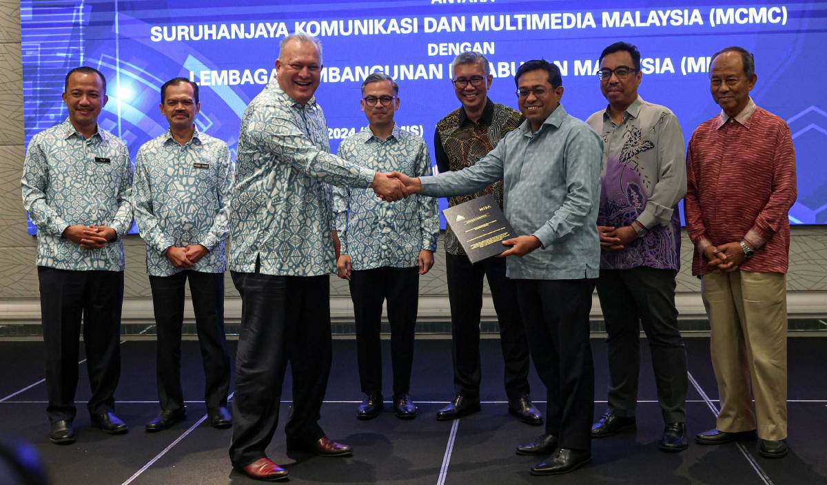 FAHMI (empat, kiri) menyaksikan pertukaran Memorandum Persefahaman (MoU) antara Suruhanjaya Komunikasi dan Multimedia Malaysia (MCMC) dengan Lembaga Pembangunan Pelaburan Malaysia (MIDA). FOTO BERNAMA