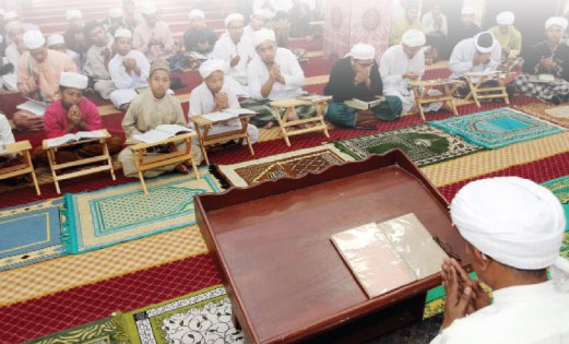 PELAJAR mengaji al-Quran yang diketuai tenaga pengajar Madrasah Ar-Rahmaniah Ad-Diniah.