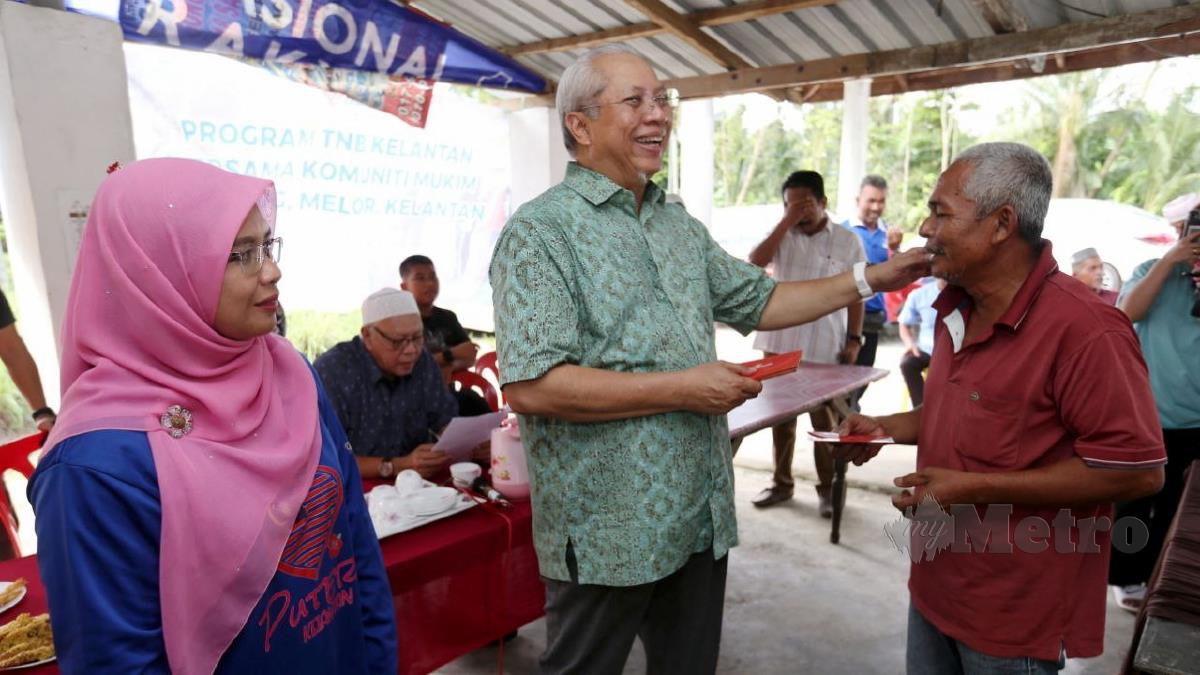 ANNUAR (dua kiri) bersama calon BN Marzuani Ardila Ariffin (kiri) memyampaikan bantuan kepada mangsa ribut di Kampung Tegayong. FOTO Nik Abdullah Nik Omar. 