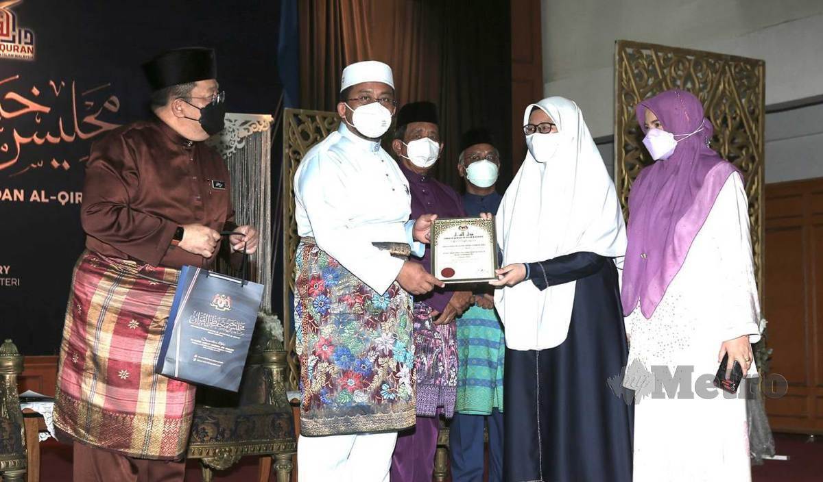 MARZUK menyampaikan Anugerah Siswi Cemerlang, Nurul Iman Raehamilizwan George di Dewan Muktamar, Darul Quran. FOTO Amirudin Sahib