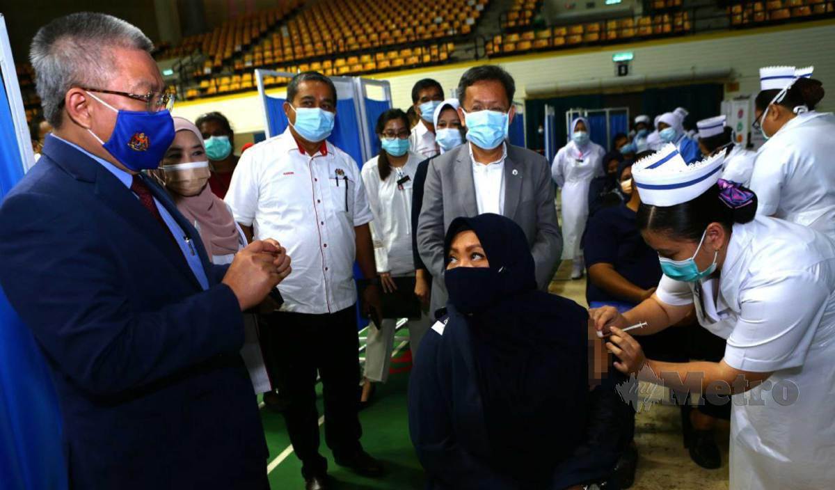 DR Adham (kiri) melawat Pusat Vaksinasi Covid-19 di Stadium Perpaduan Petra Jaya. FOTO Nadim Bokhari