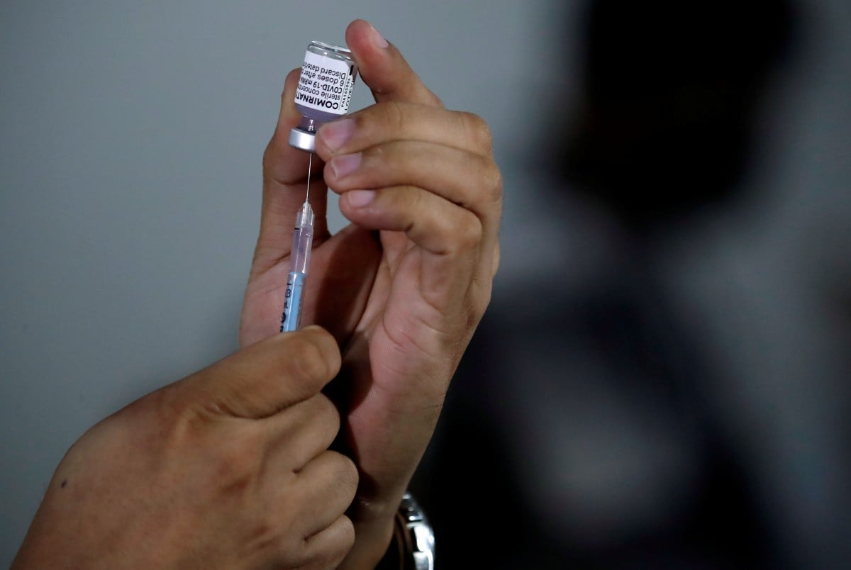 PETUGAS kesihatan menyediakan dos vaksin Pfizer di pusat vaksinasi di Manila, Filipina. FOTO EPA.
