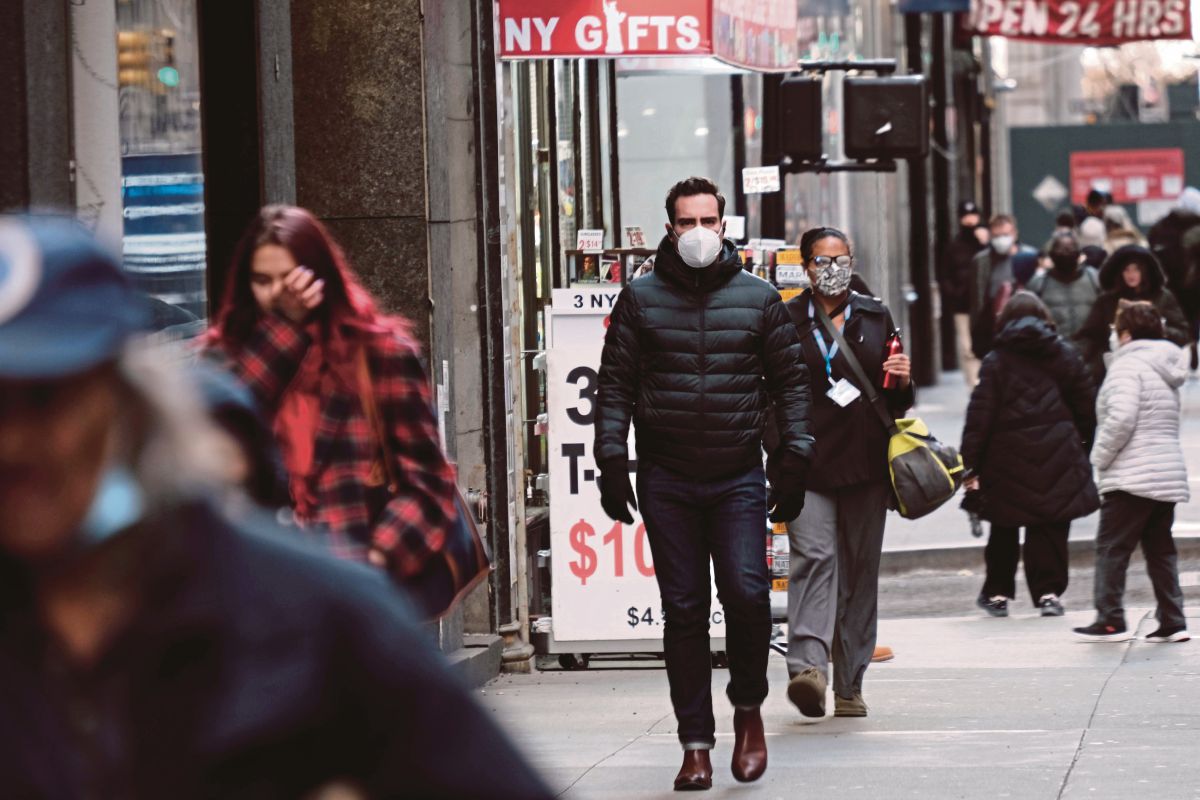 ORANG ramai memakai pelitup muka ketika berjalan-jalan di Manhattan, New York. FOTO AFP 