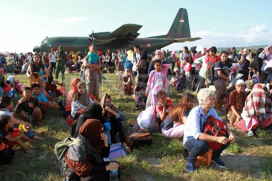 PENDUDUK menunggu untuk dibawa keluar dari lokasi bencana di Lapangan Terbang Mutiara Sis Al Jufri di Palu, Sulawesi. FOTO Reuters/Antara Foto/Akbar Tado