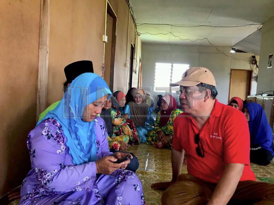 AHLI Parlimen Igan, Ahmad Johnie Zawawi menenangkan Halimah Geronggong, 42, (kiri) dan suaminya, Ali Bengang, 53, ketika menziarahi keluarga Allahyarham Yahya di Kampung Tian Matu, Mukah. FOTO Khalid Latip