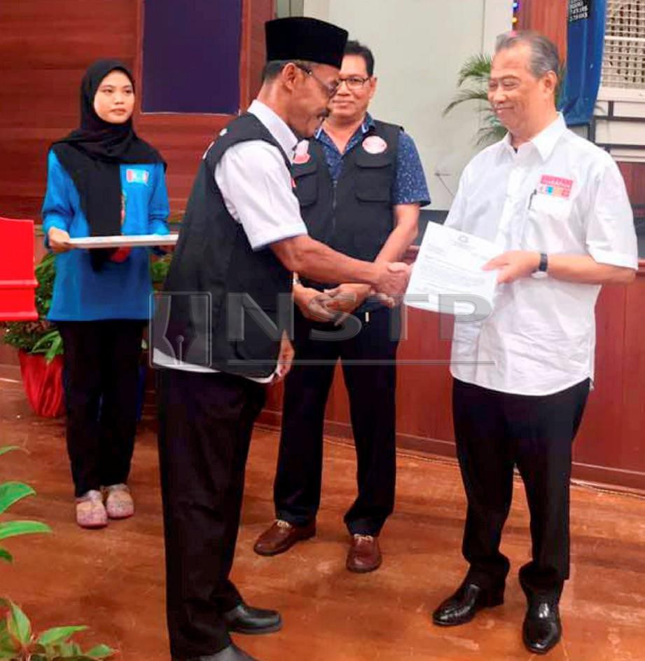 MUHYIDDIN (kanan) menyampaikan sijil tauliah kepada pegawai lantikan khas. FOTO Mohd Farid Noh