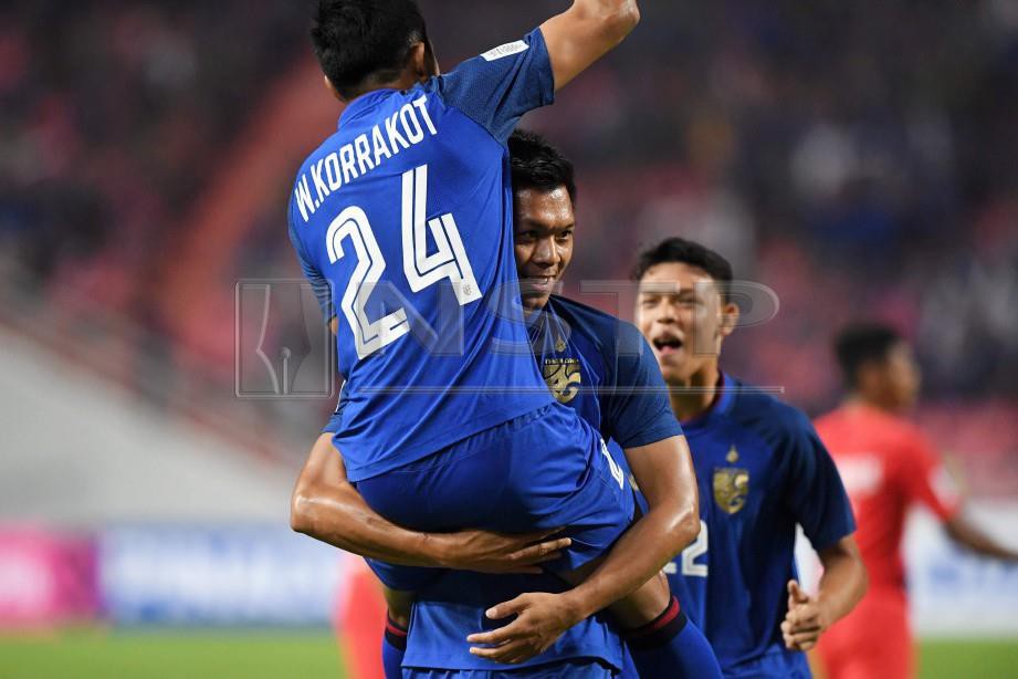 PEMAIN pertahanan Thailand, Pansa Hemviboon (tengah) meraikan gol bersama Korrakot Wiriyaudomsiri ketika perlawanan Piala AFF 2018 dengan Singapura di Stadium Nasional Rajamangala, Bangkok. FOTO AFP
