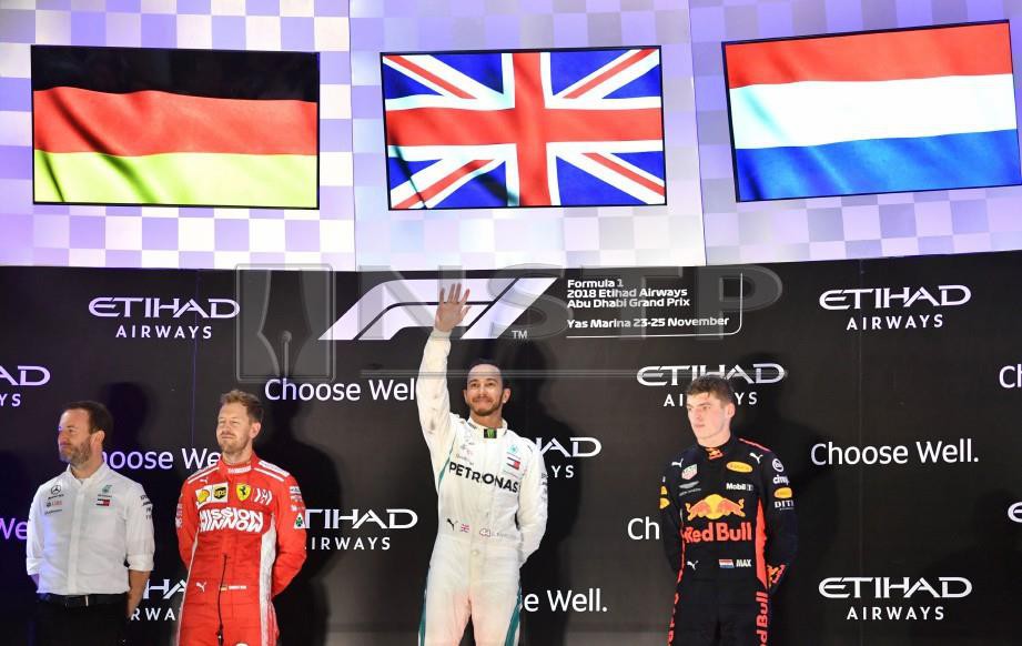SEBASTIAN Vettel (dua kiri), Lewis Hamilton (dua kanan) dan Max Verstappen (kanan) selepas perlumbaan F1 di Abu Dhabi. FOTO AFP