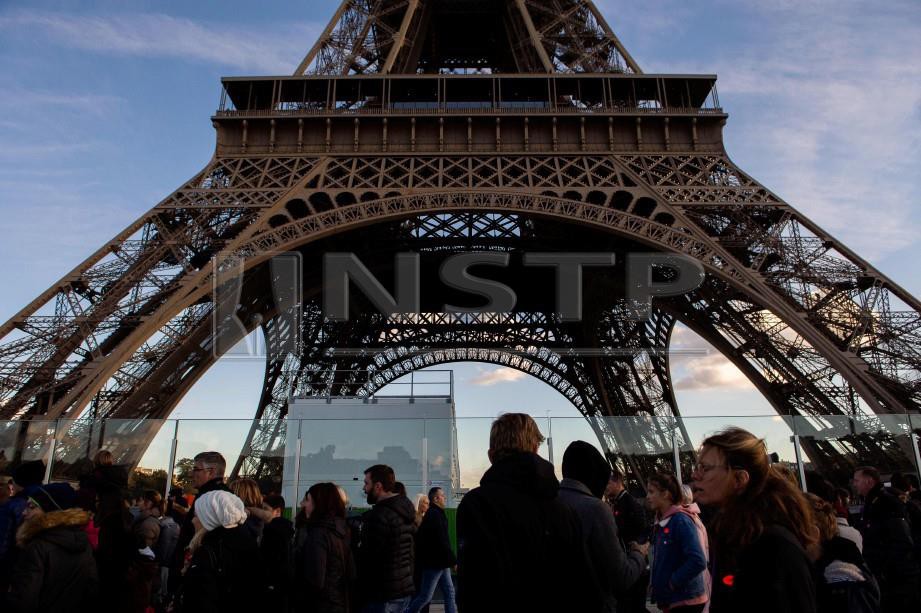 ORANG ramai berjalan di perkarangan Menara Eiffel pada 2 November 2018. FOTO AFP