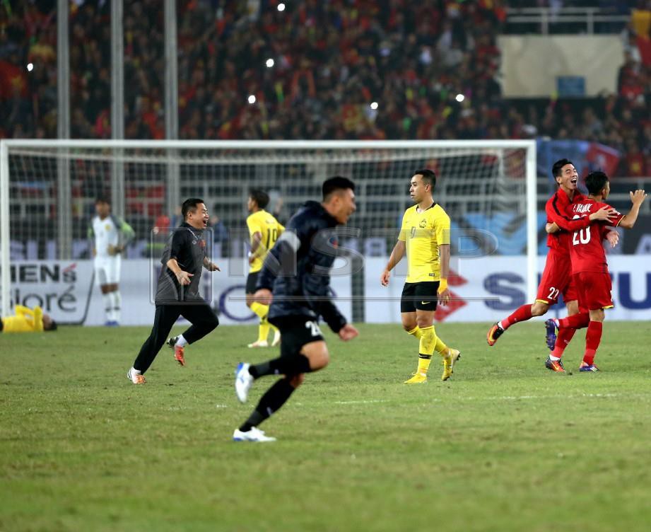 PEMAIN Vietnam (kanan) meraikan kejayaan selepas menumpaskan Malaysia pada perlawanan akhir kedua Piala AFF 2018 di Stadium My Dinh Vietnam, semalam. FOTO Mohamad Shahril Badri Saali