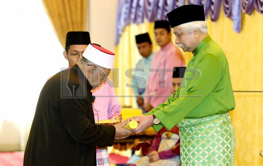 TUANKU Muhriz berkenan menyampaikan watikah Pentauliahan Ahli Jawatankuasa Fatwa kepada Mufti Kerajaan Negeri Sembilan, Datuk Mohd Yusof Ahmad. FOTO Iqmal Haqim Rosman