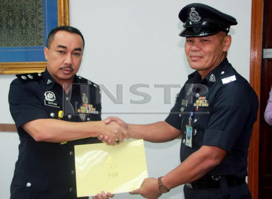 SUFFIAN (kiri) menyampaikan sijil kepada Sulaiman sebagai penghargaan terhadap tindakannya menyelamatkan kucing. FOTO  ihsan Polis