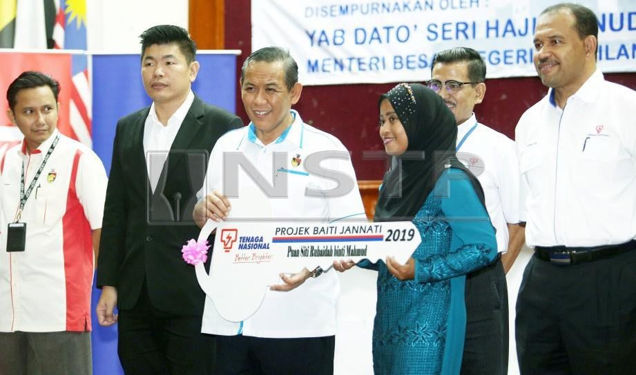  Aminuddin menyampaikan kunci projek rumah program Baiti Jannati TNB kepada Siti Ruhaidah. FOTO Hazreen Mohamad