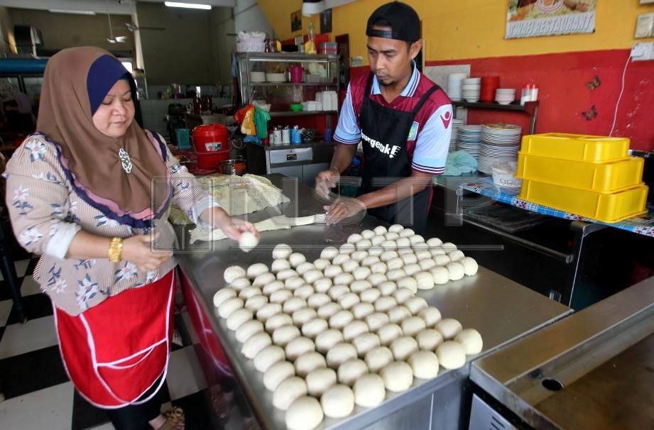 ROSNIDA bersama pekerjanya menyusun tepung roti canai ketika temui di Restorannya D'Wafi. FOTO Muhd Asyraf Sawal