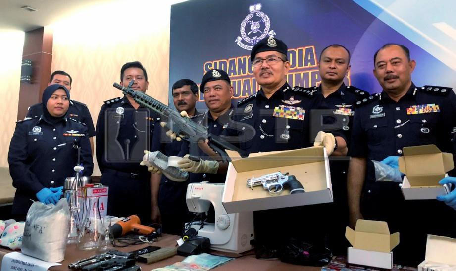 MAZLAN (dua dari kanan) menunjukkan senjata api yang dirampas. FOTO NSTP 