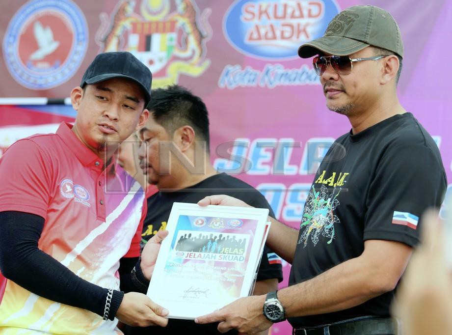 Mohd Azis (kanan) menyampaikan Watikah Pelantikan Jawatankuasa Kecil Skuad AADK kepada wakil  Rumah Pangsa Tanjung Aru. FOTO Malai Rosmah Tuah