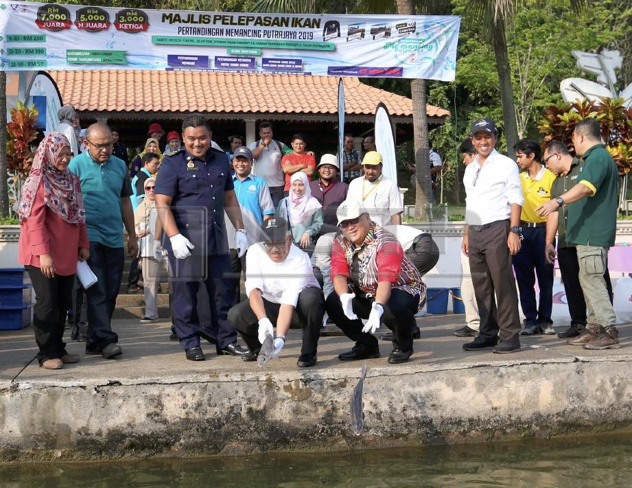AMINUDDIN (duduk kanan) bersama Omairi ketika majlis Pelepasan Ikan Pertandingan Memancing Putrajaya 2019. FOTO Ahmad Irham Mohd Noor