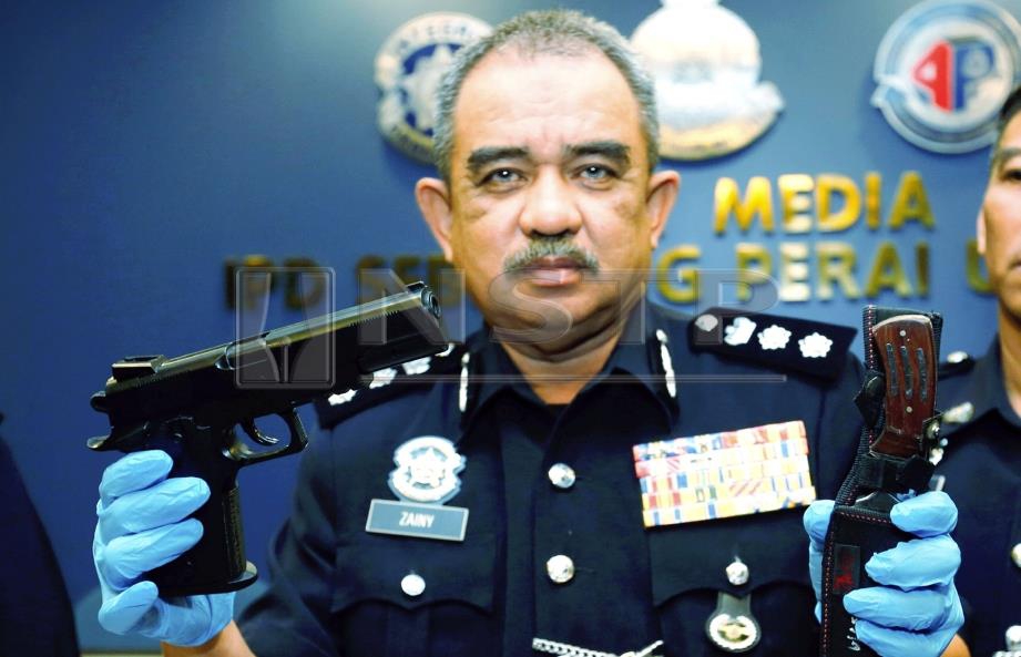 Noorzainy Mohd Noor (kiri) menujukkan sepucuk pistol tiruan dan sebilah pisau yang dirampas dari geng samun semasa sidang media di bilik media Ibu Pejabat Polis Daerah Seberang Perai Utara, Kepala Batas, Pulau Pinang. FOTO Ramdzan Masiam