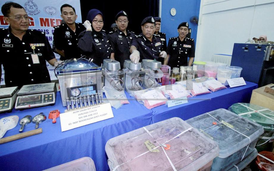 ZULKIFLI (dua dari kanan) menunjukkan sebahagian daripada peralatan memproses dadah yang dirampas. FOTO Muhammad Zuhairi Zuber