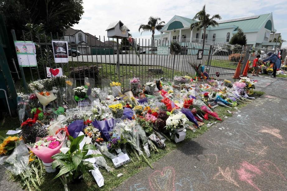 PENDUDUK meletakkan bunga di perkarangan Masjid Umar mosque di Auckland bagi memperingati mangsa yang terkorban dalam serangan di Christchurch. FOTO AFP