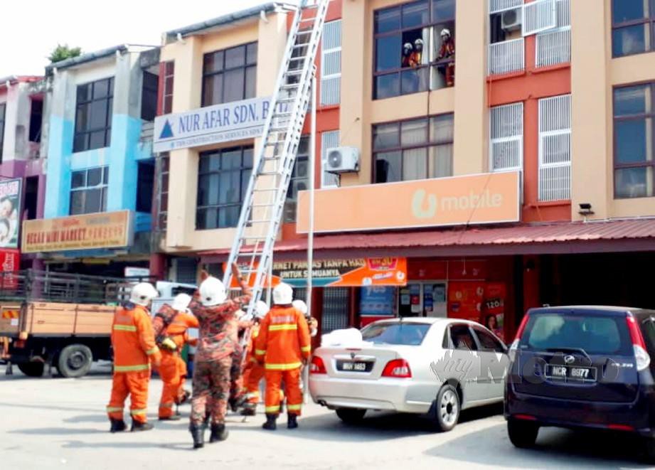 ANGGOTA bomba membantu menyelamatkan enam penghuni yang terperangkap apabila sebuah hotel di Dataran Segar, Lukut, terbakar petang tadi. FOTO ihsan bomba.