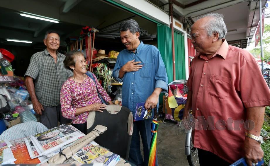 Tok Mat beramah mesra bersama Chua Eng Kia, 80, (dua dari kiri) ketika berkempen di Kuala Sawah, Rantau. FOTO Iqmal Haqim Rosman