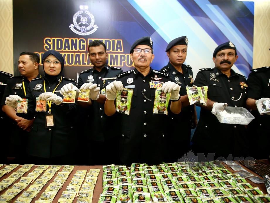 Mazlan (tengah) menunjukkan dadah yang dirampas polis. Mohd Khairul Helmy Mohd Din