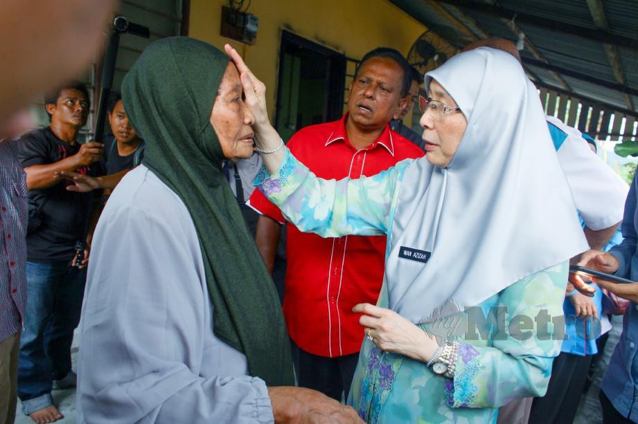 Dr Wan Azizah beramah mesra bersama warga emas, Ramlah Silong, 79, ketika melawat Kampung Stesen. FOTO Adzlan Sidek