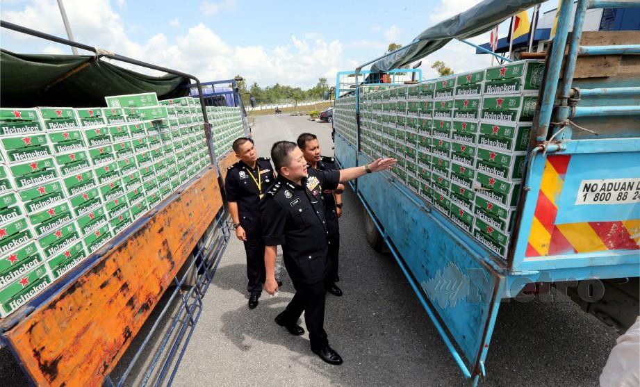 KHAW menunjukkan beberapa kotak minuman keras dirampas Pasukan Gerakan Am Sarawak. FOTO/ L Manimaran