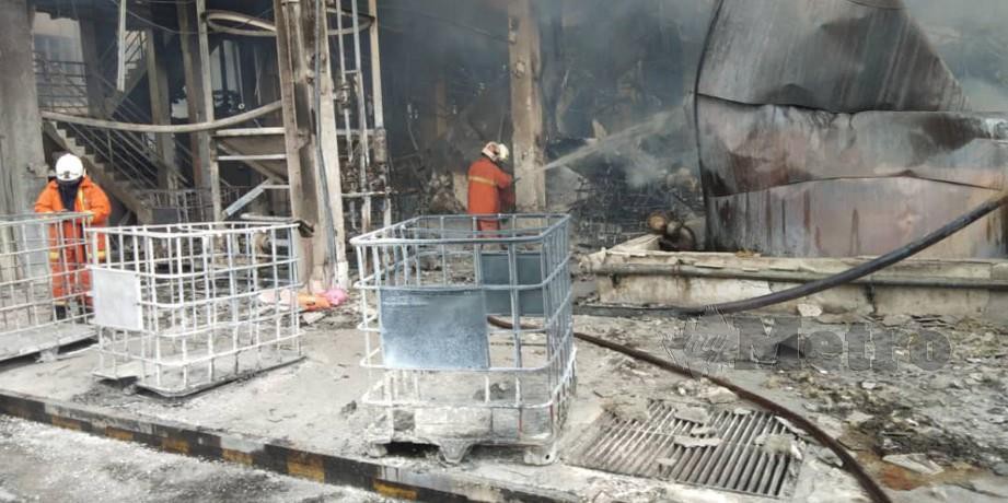 ANGGOTA bomba berusaha memadamkan kebakaran kilang di Jalan Perigi Nenas, Pulau Indah. FOTO/ Ihsan Bomba