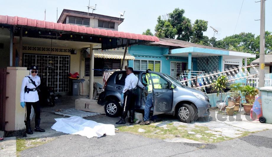 Anggota polis memeriksa mayat mangsa yang maut selepas kereta dipandunya terbabas. FOTO Khairunisah Lokman