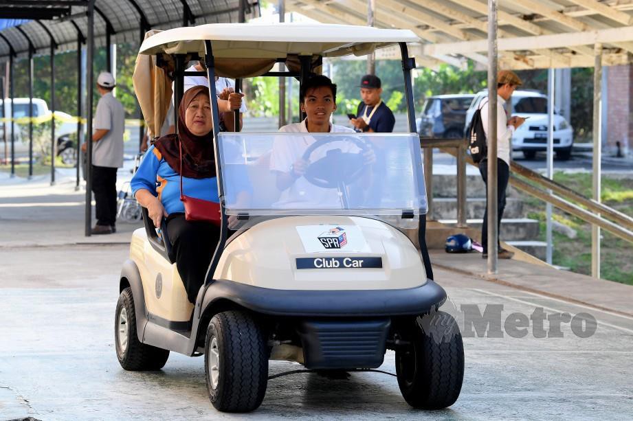 PETUGAS SPR menggunakan ‘buggy’ untuk membawa pengundi kurang upaya dan warga emas ke pusat mengundi. FOTO Bernama