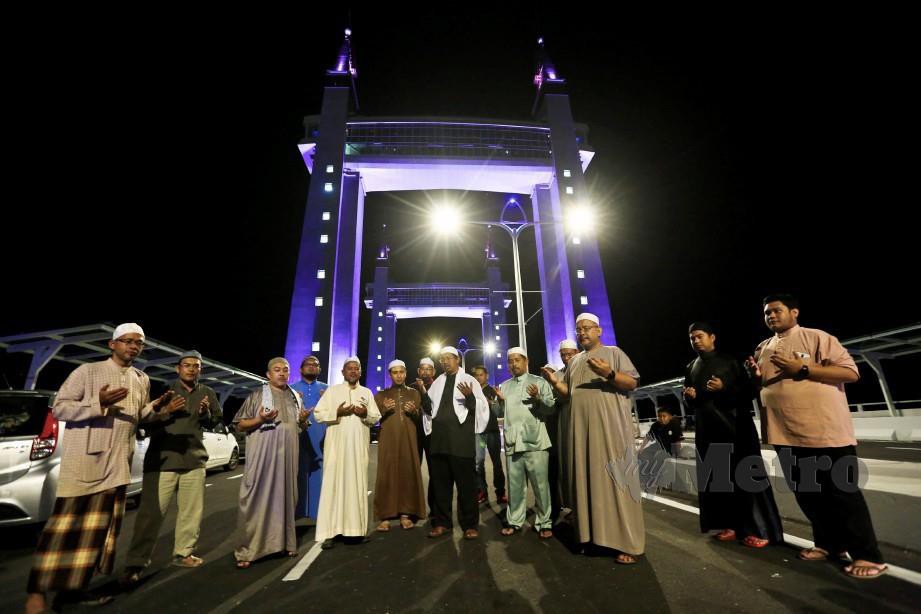 JEMAAH berdoa selepas menunaikan solat hajat yang diimamkan oleh Mohd Nor Hamzah di atas  Jambatan Angkat menjelang pembukaannya. FOTO Ghazali Kori