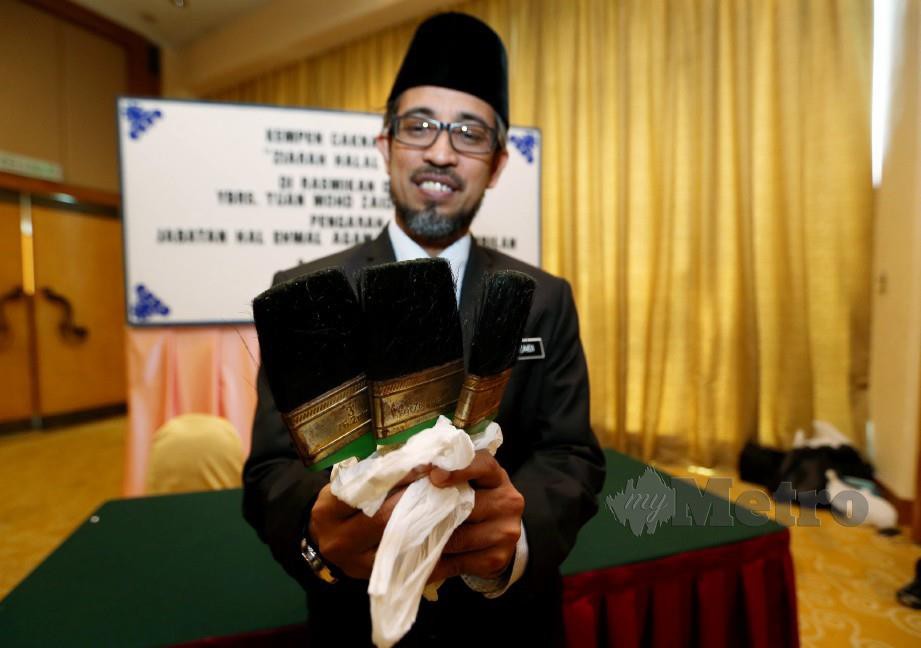 Mohd Zaidi menunjukkan berus dipercayai diperbuat dari bulu babi yang dirampas dari sebuah restoran hari ini. FOTO Iqmal Haqim Rosman
