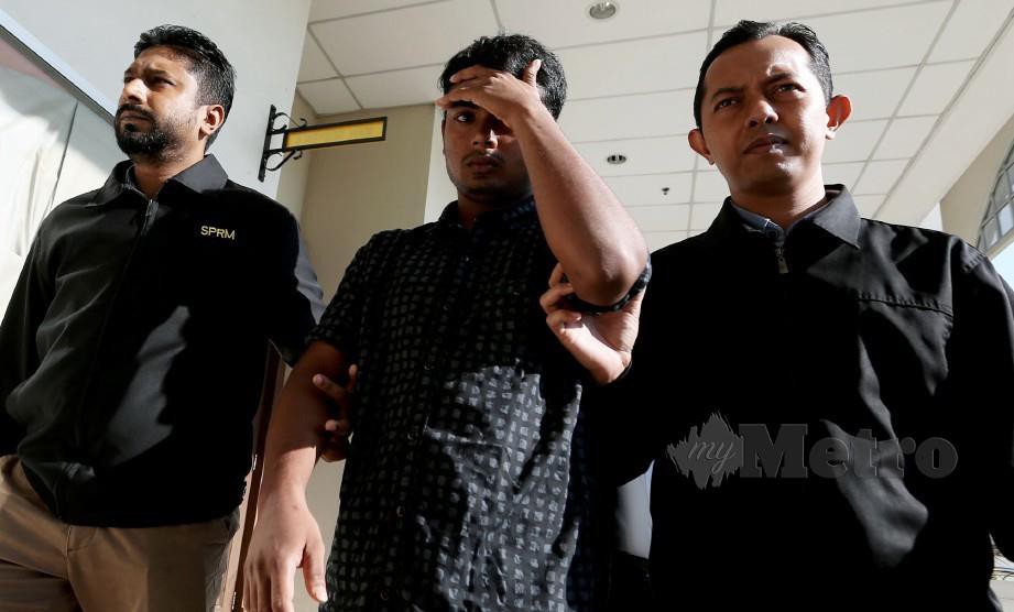 Penguat kuasa SPRM mengiringi tertuduh yang dijatuhi hukuman penjara tiga bulan dan denda RM10,000. FOTO Iqmal Haqim Rosman