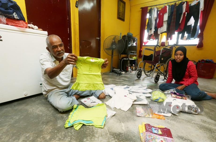 Husain bersama Nurul Sholihah menyusun pakaian untuk dijual di kediaman mereka di PPR Lembah Subang. FOTO Rohanis Shukri