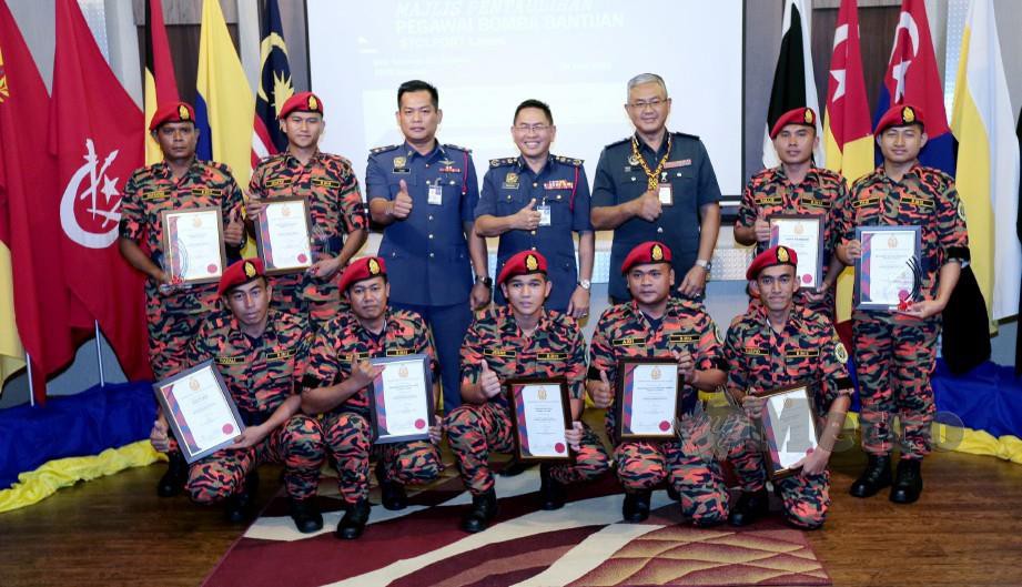 KHIRUDDIN dan Pengurus Besar Airport Fire and Rescue Services Malaysia Airport, Abdul Malik Mohd Yunus bersama sembilan pegawai bomba yang menerima sijil pada Majlis Pentauliahan Pegawai Bomba Bantuan STOLPORT Lawas. FOTO Hazreen Mohamad