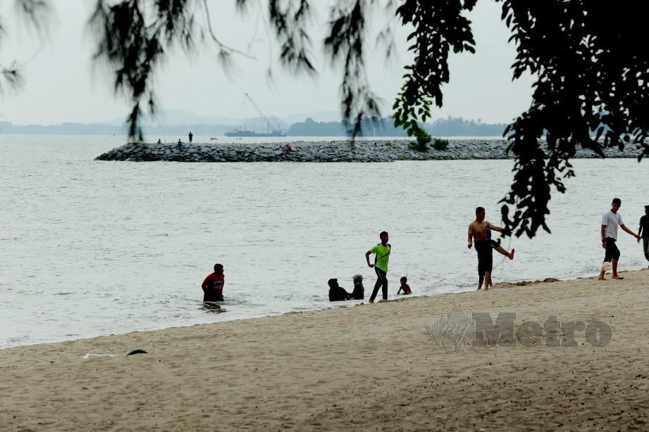 Pengunjung mandi manda di Pantai Pengkalan Balak walaupun tular banyak obor-obor di pantai itu. FOTO Khairunisah Lokman
