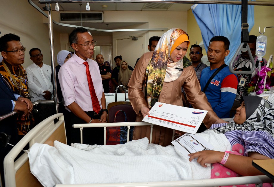 RINA menyerahkan replika cek bernilai RM22,000 kepada ibu arwah di Hospital Putrajaya, hari ini. FOTO BERNAMA.