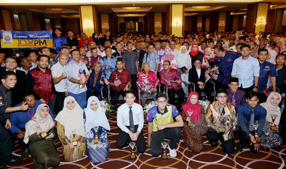 Tun Dr Mahathir (tengah) bergambar bersama pelajar cemerlang sekolah dan IPT di Melaka. FOTO Khairunisah Lokman
