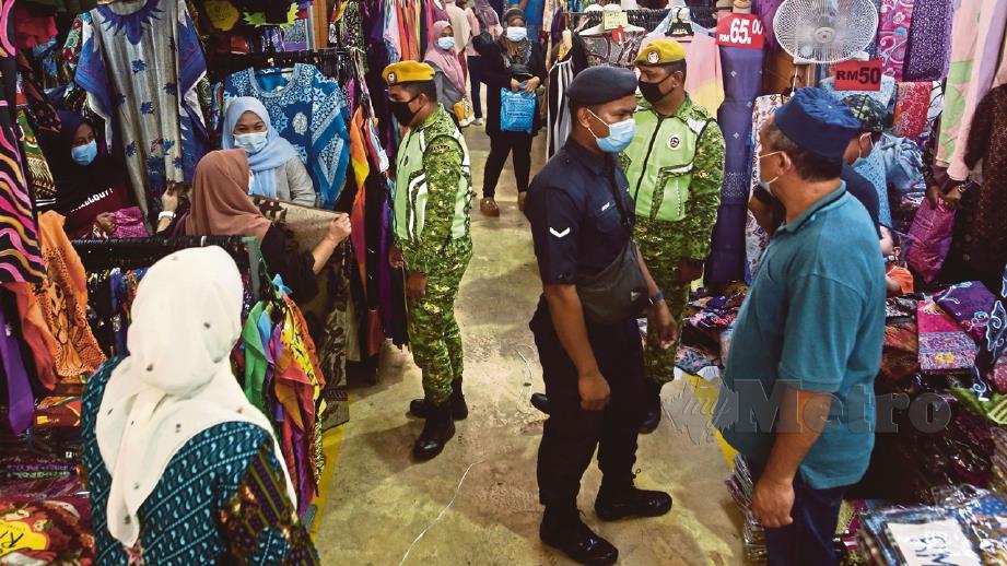 ANGGOTA polis memastikan orang ramai mematuhi SOP di Pasar Payang, Kuala Terengganu, Ogos lalu. FOTO arkib NSTP