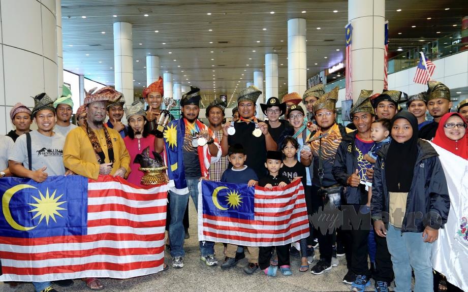 MOHD Safwan, Muhamad Akmal, Mohd Nasrul dan Lee bergambar bersama penyokong sebaik tiba di KLIA. FOTO Ahmad Irham Mohd Noor