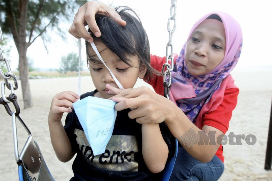 TOPENG menutup hidung dan mulut jenis N95 yang dipakaikan Siti Aishah Mohd Nordin, 33, kepada anaknya, Nur Balqis Natasya Muhammad Baharin, 5. FOTO Arkib NSTP.