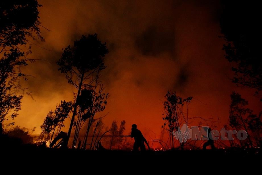 ANGGOTA bomba berusaha memadamkan kebakaran hutan di Palangka Raya, Kalimantan pada 14 September 2019. FOTO Reuters