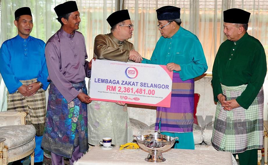 Sultan Sharafuddin Idris Shah (dua, kanan) berkenan menerima zakat perniagaan daripada Azahari (tiga, kiri) berjumlah RM2.36 juta di Istana Bukit Kayangan Shah Alam hari ini. FOTO Bernama