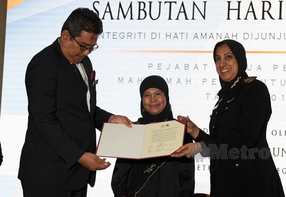 Tengku Maimun (tengah) melihat Ketua Pendaftar Mahkamah Persekutuan Malaysia Tuan Ahmad Terrirudin Mohd Salleh (kiri) menyerahkan Ikrar Bebas Rasuah (IBR) kepada Latheefa. FOTO Bernama